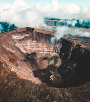 Clouds rolling over the opening of a volcano.